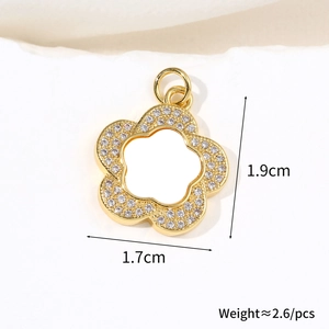 Macro detail of gold flower pendant with zircons and shell petals showing 1.9cm height