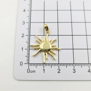 Detail of 2.5cm gold sunflower pendant showing radial curved rays on white background