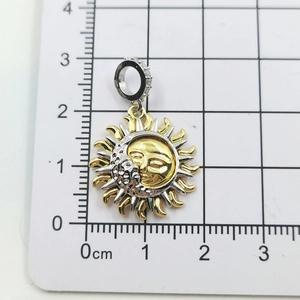Detailed size view of a sun and moon gold pendant showing diameter of 2.5cm on scale