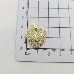 Close-up of golden angel wing heart pendant with sparkling white cubic zirconia stones