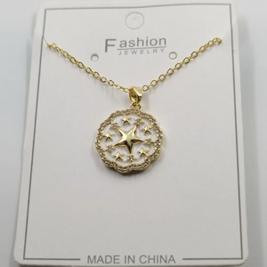 Detailed macro view of a gold starburst heart pendant with inlaid crystals on a card