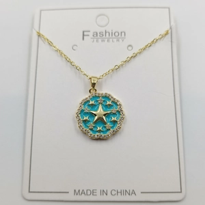 Detailed close-up of a blue enamel sunburst star pendant on a gold chain necklace