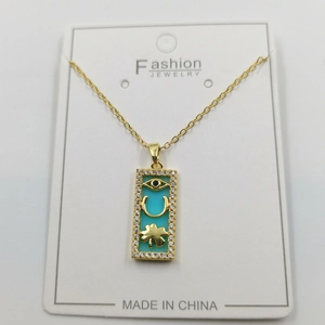 Detail of gold necklace with rectangular blue pendant featuring clover and lucky charms