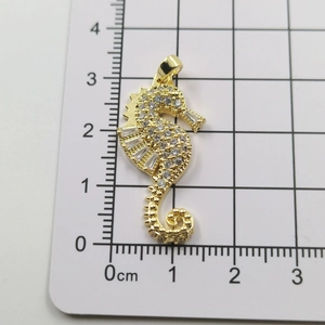 Detailed view of seahorse pendant in gold finish with white cubic zirconia pavé setting