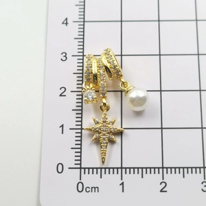 Detail view of gold octagonal star pendant with pearls on a measurement scale ruler