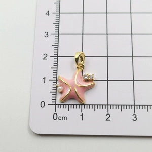 Pink starfish pendant with pearls and zircons measured at 1.5cm on a grid scale