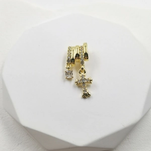 Macro shot of gold layered necklace featuring a zircon stone and gothic cross pendant