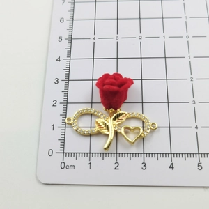 Detail of red rose pendant with gold infinity heart symbol and sparkling rhinestones