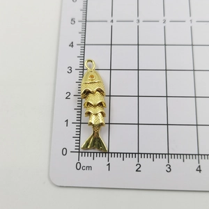 Detailed macro view of 18k gold plated articulated fish pendant showing 3.5cm length