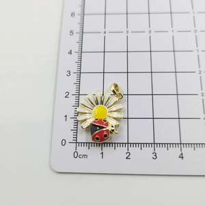 Macro detail of daisy and ladybug pendant showing 20mm size on measurement board