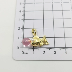 Macro shot of 18k gold plated goldfish pendant with zircon and pearl details