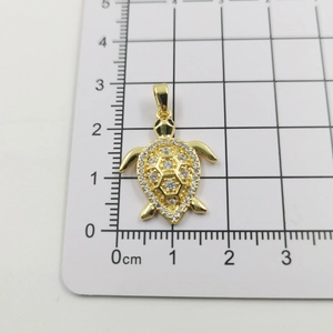 Detailed scale measurement of a golden sea turtle pendant with micro-pave zircons