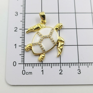 Detailed view of turtle pendant with white enamel shell and measurements scale