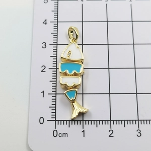Detailed view of a 3.5cm articulated fish pendant in gold metal with blue enamel and zircon