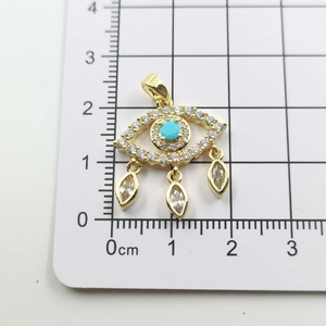 Macro shot of gold-plated evil eye pendant with turquoise stone and sparkling crystals