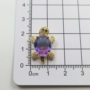 Detailed size view of sea turtle pendant with purple gem and sparkling crystals