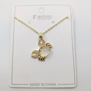 Golden crab pendant necklace with white gemstone and sparkling crystal accents