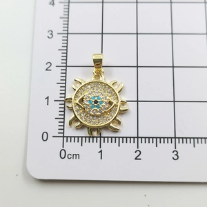 Detail shot of golden evil eye sun pendant measured on scale showing 1.7cm diameter