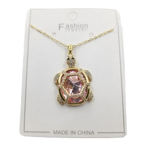Golden turtle pendant necklace with a large pink gemstone and white zircon accents
