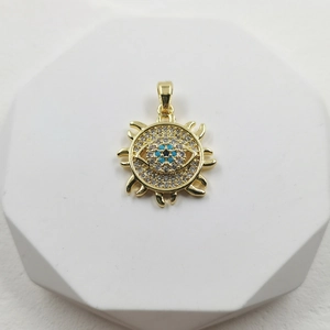 Golden Sun of Eye pendant with blue crystal and shimmering zircons on a white pedestal
