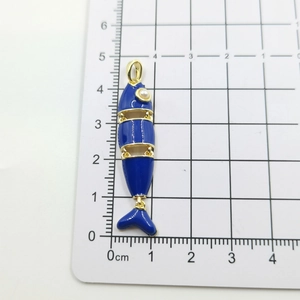 Dettaglio di un ciondolo a forma di pesce blu smaltato con occhio di perla da 4,5 cm