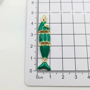 Dettaglio del ciondolo a pesce snodato in smalto verde con occhio di perla e oro