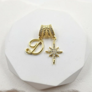 Detailed close-up of gold-plated pendant with sparkling zircon star and letter D charm
