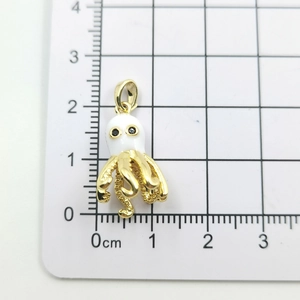 Macro shot of 18k gold plated octopus pendant with white enamel and grid measurement