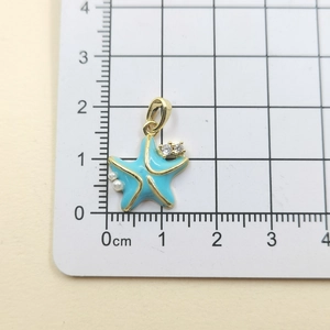 Detailed view of light blue starfish pendant with white pearls and gold accents