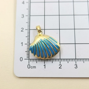 Detail shot showing 1.8cm x 2.2cm blue shell pendant with golden enamel and scale ruler