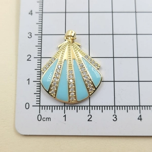 Detail of seashell pendant with blue enamel and zircon stripes showing 2.5cm size scale