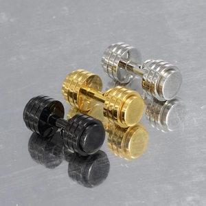Macro shot of silver, gold and black dumbbell stud earrings in polished titanium steel