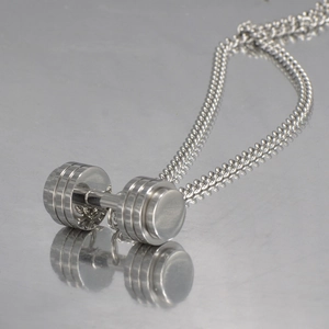 Macro detail of polished stainless steel dumbbell pendant with a sleek curb chain