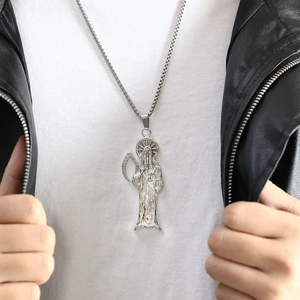 Détail du pendentif Santa Muerte sur chaîne en acier argenté porté par un mannequin homme