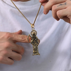 Vue détaillée du pendentif Santa Muerte en or vintage sur une chaîne maille gourmette