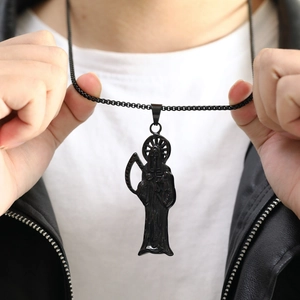 Gros plan d'un pendentif Santa Muerte noir porté par un homme en veste en cuir