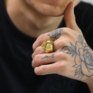 Detailed view of a gold-plated stainless steel signet ring with religious relief design
