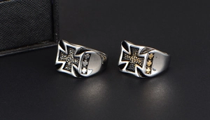 Detailed macro view of two men's stainless steel punk rings with iron cross relief