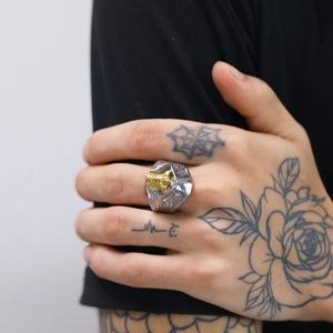 Close-up of a men's vintage gothic stainless steel ring with a golden skull on hand