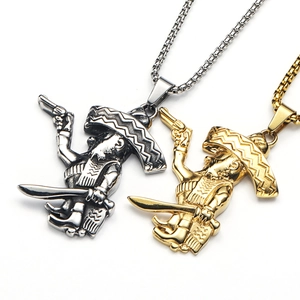 Detalle de colgantes mexicanos vintage en oro y plata con sombreros y armas