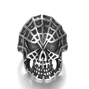 Primer plano de anillo de calavera punk en acero con detalle grabado de telaraña