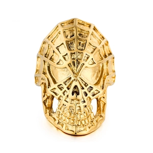 Detalle de anillo de calavera punk dorado con textura de telaraña y acabado metálico brillante