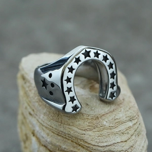 Macro shot of horseshoe-shaped stainless steel ring with black star patterns