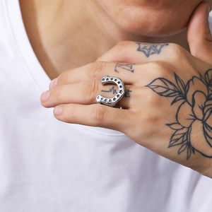 Close-up of vintage silver horseshoe ring with star engravings on model's finger