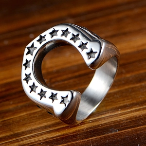 Polished stainless steel horseshoe ring featuring ten engraved stars on wood background