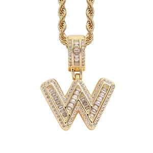 Macro detail of gold-plated letter W pendant with sparkling baguette-cut zircons and rope chain