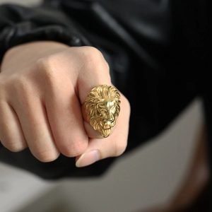Macro detail of golden lion head ring showcasing intricate metal relief and bold punk style
