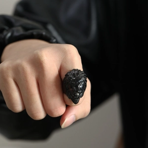 Close-up of black lion head ring with punk design worn on finger for rock style