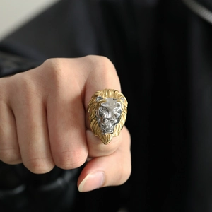 Detailed view of a two-tone lion head ring in gold and silver on a model's hand
