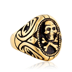 Dettaglio di un anello sigillo vintage con teschio dorato e incisioni tribali gotiche